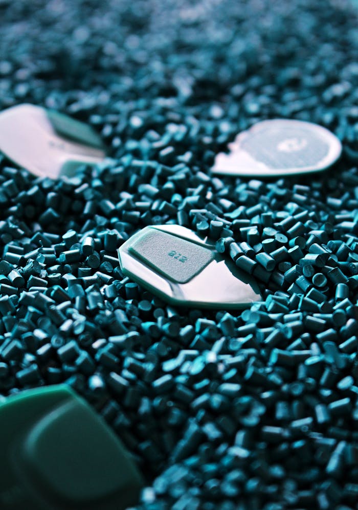 who-we-are Detailed view of green guitar picks surrounded by textured plastic pellets.