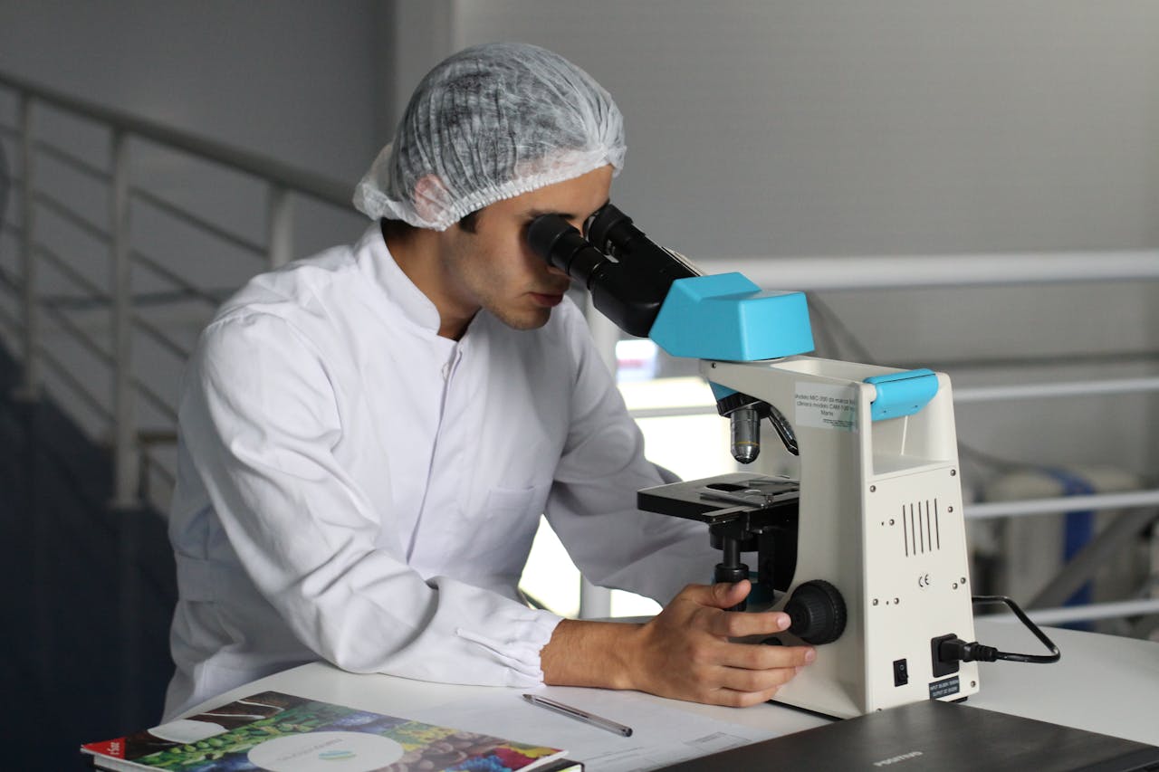 heros-img Scientist in a lab coat using a microscope to conduct research, focusing on healthcare improvements.