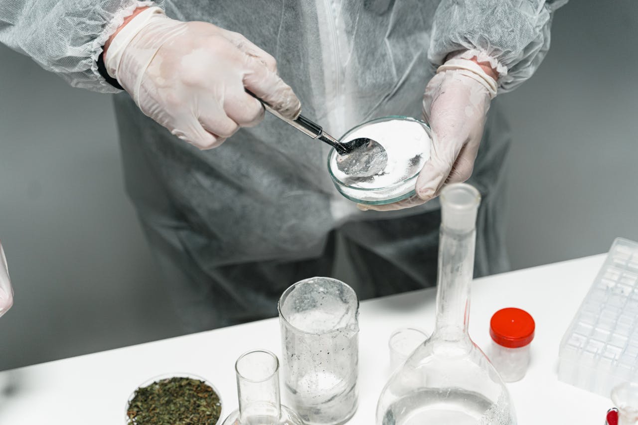 our-story Scientist in protective gear handling powder sample in a sterile lab environment.